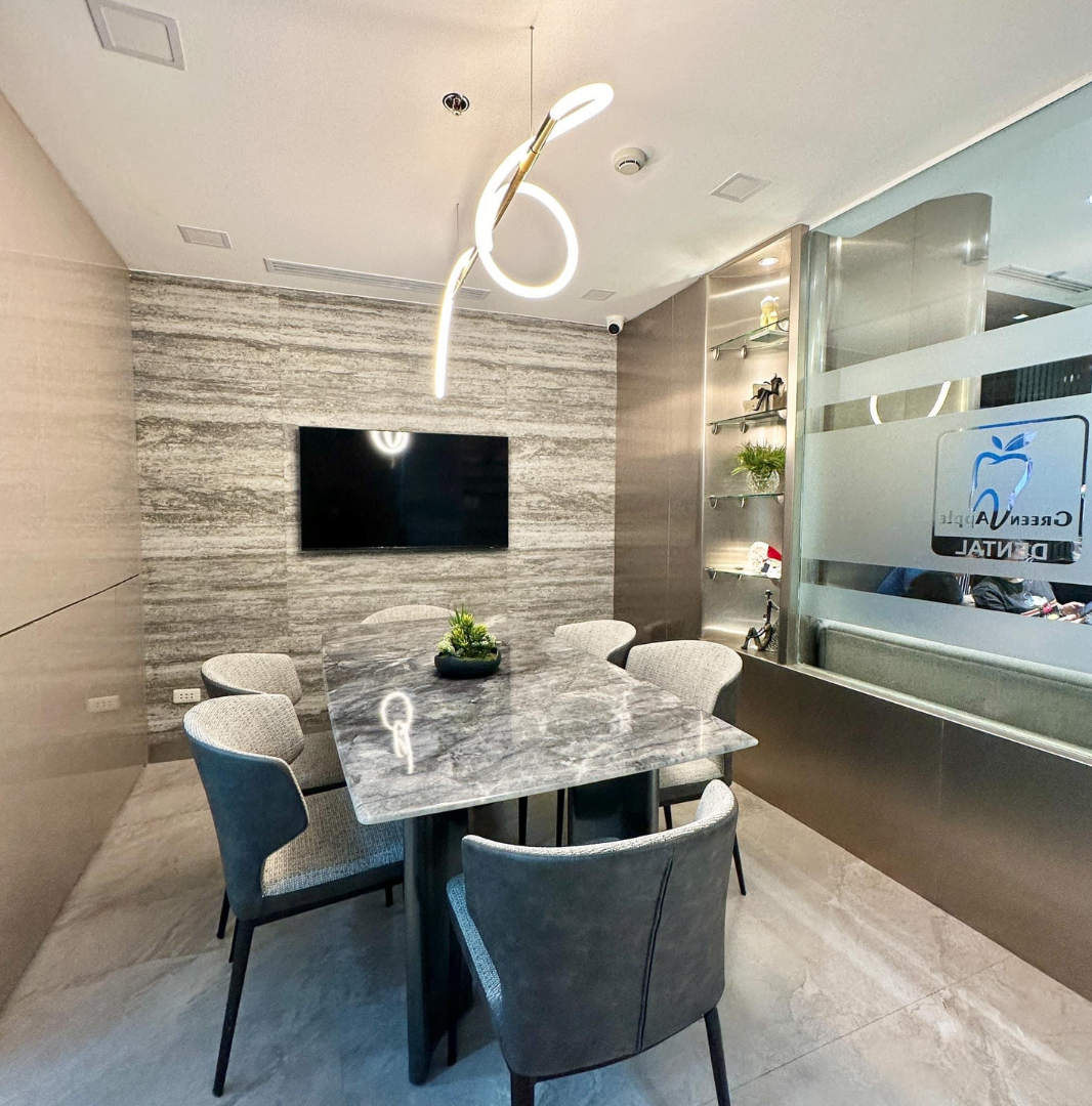 Urbidontics consultation room with marble table, sculptural ceiling light, and clinic glazing.