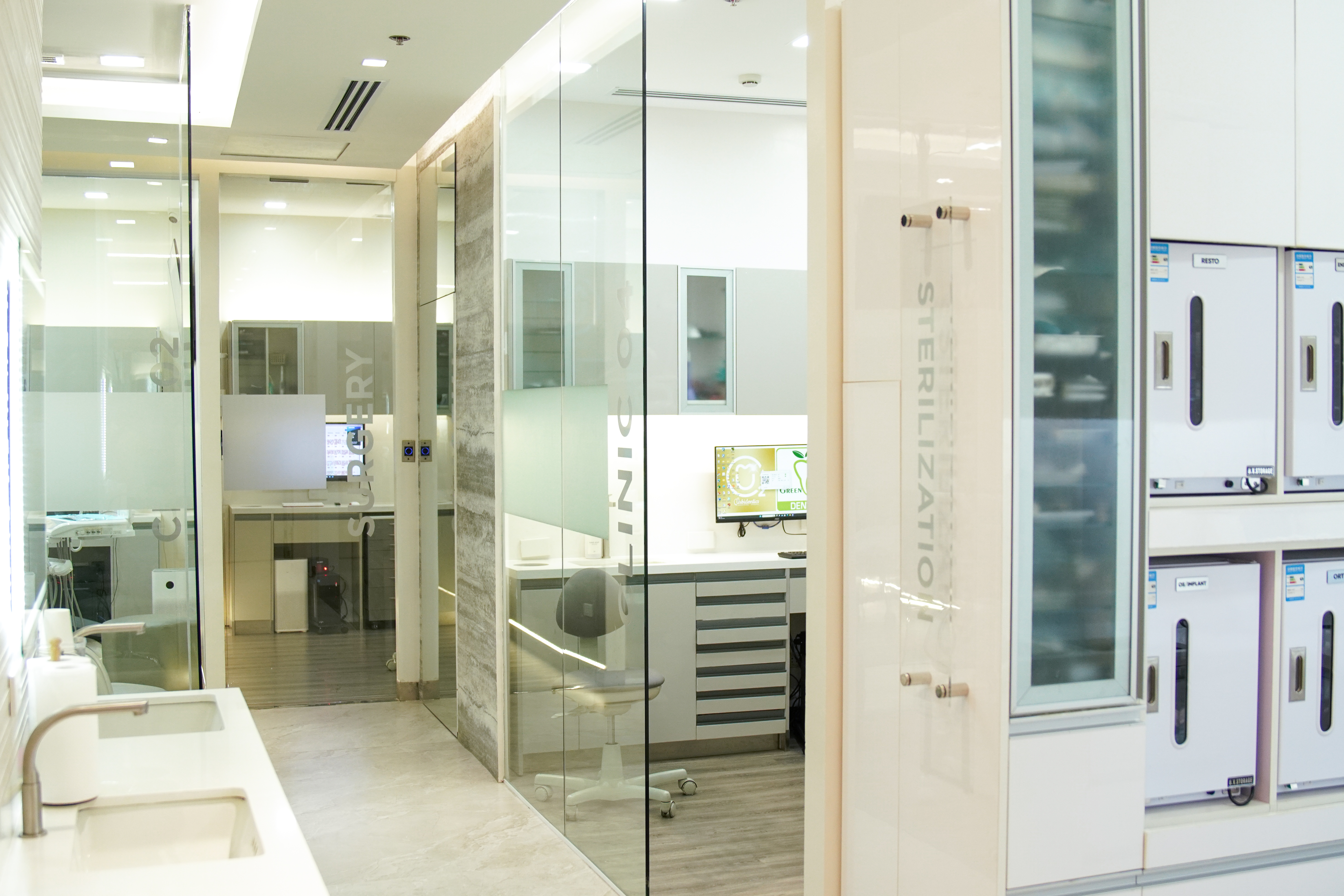 Wide view through the Urbidontics sterilization and clinical corridor, showing the clinic's glass partitions and equipment.